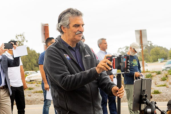 Man holds phone to record video footage.